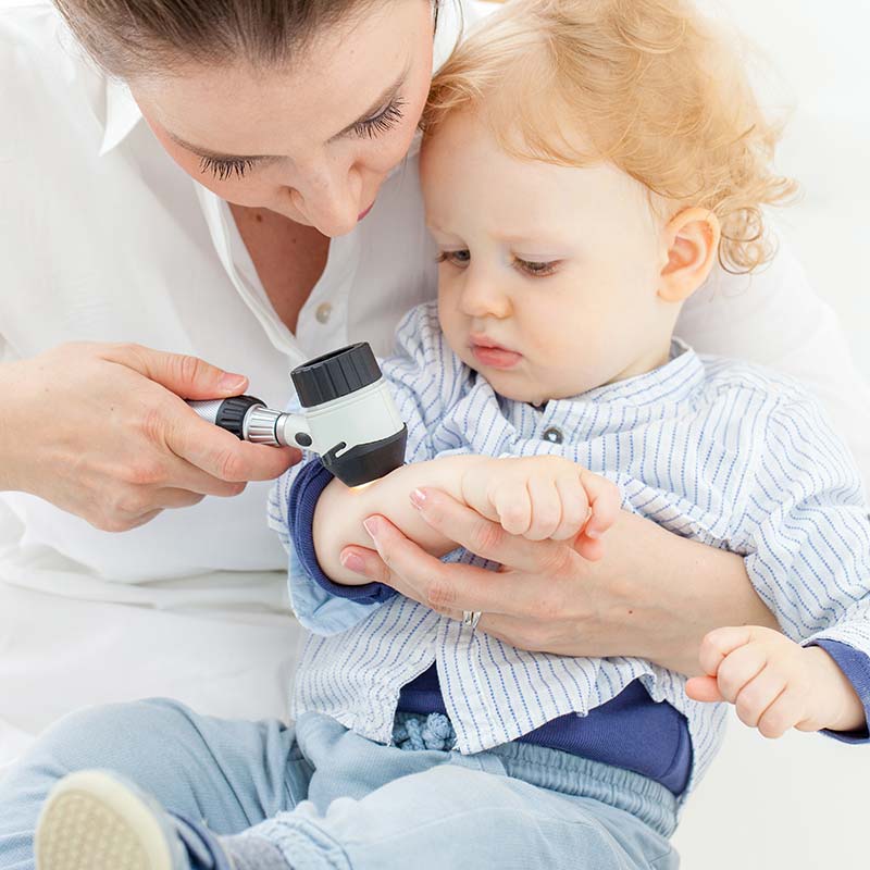 Dermatologist caring for a young child during a pediatric dermatology visit at Lakewood Ranch SR 70