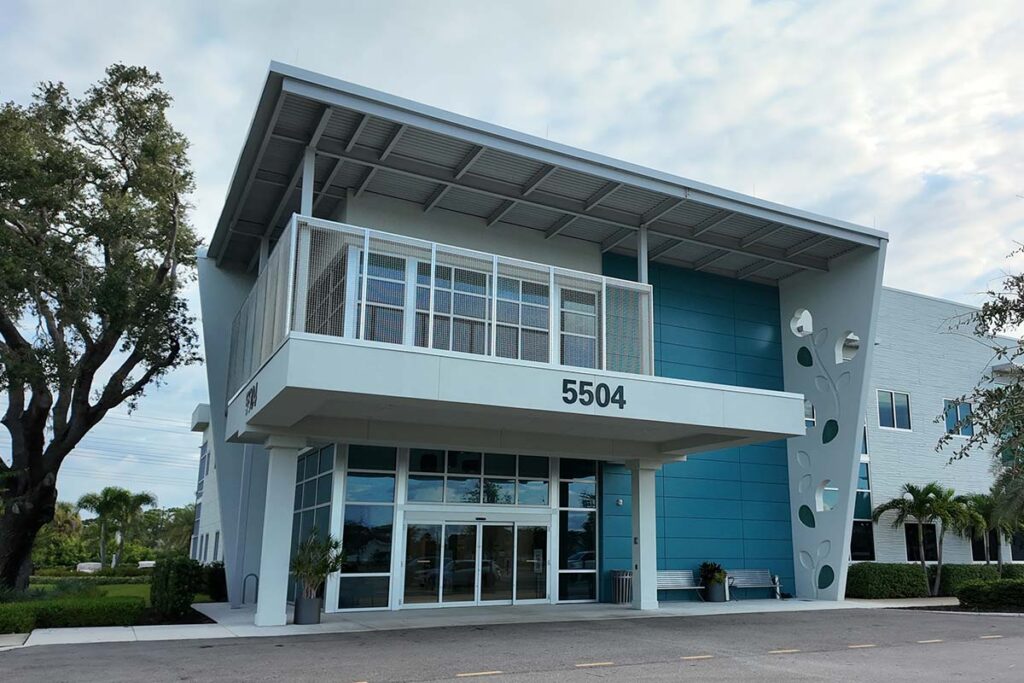 Exterior view of the Arsenault Dermatology Venice office with columned entrance and tile roof.